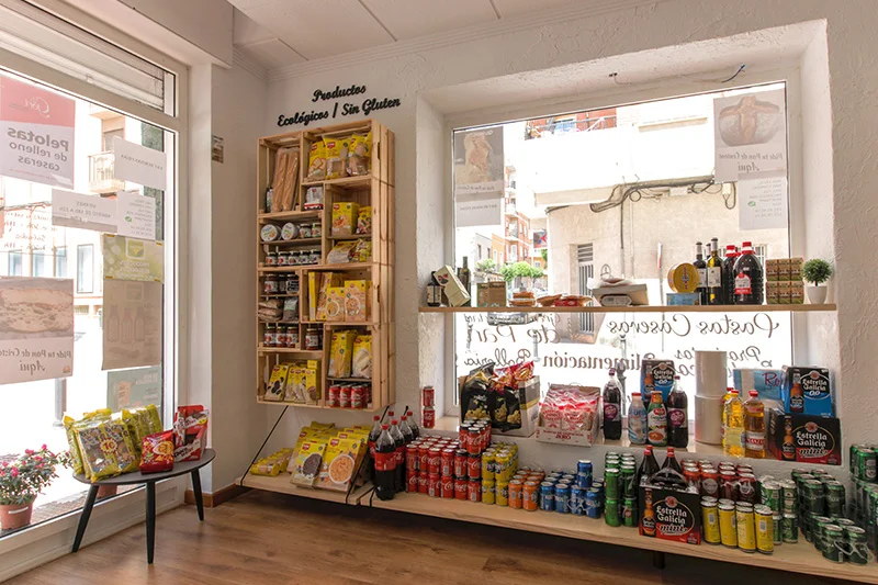 La madera es protagonista en la solución de almacenamiento y exposición de los productos. Tanto en forma de estanterías como de cajas de frutas colgadas en la pared. 